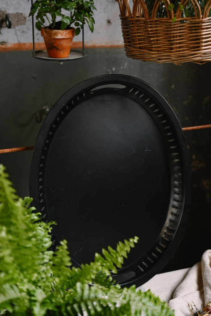 svart oval bricka i plåt med handtag